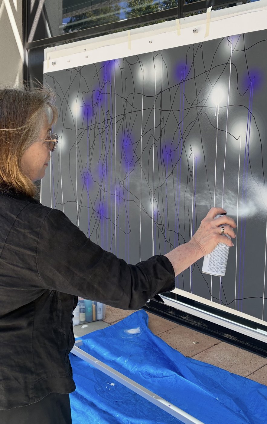 Anne Scott Wilson spray-painting Kinetitude #1, a large drawing of black, white and violet lines